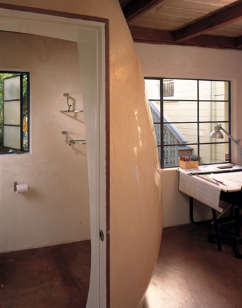 
Marmelino, a mixture of Venetian plaster and marble chips, turned the office bathroom into a sculpture the couple call the “Botero egg.” Inside, two Volvo side windows are the perfect size for mounted wall shelves.

